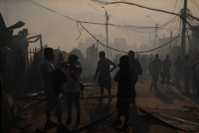 A group of people stand outside their homes in Valparaiso, Chile, Monday, Jan. 2, 2017. Image: AP Photo/Luis Hidalgo
